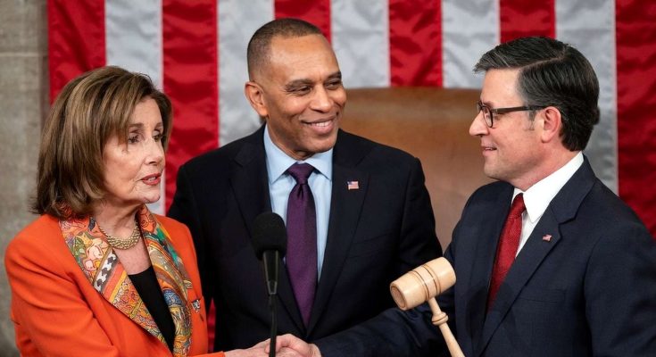 Three people in formal attire standing in front of an American flag, with one holding a