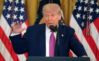 Trump speaking at podium with American flags