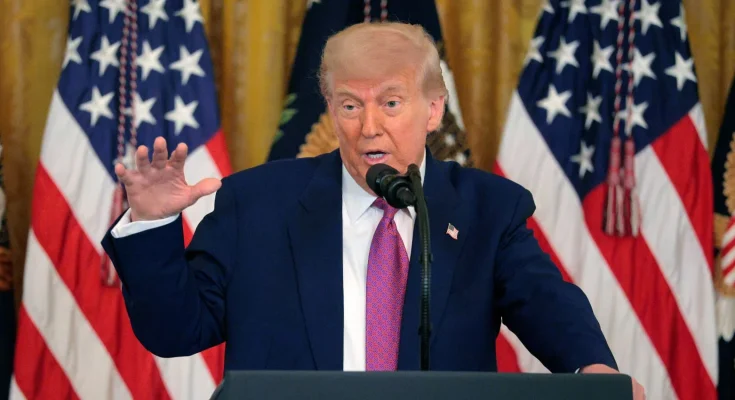 Trump speaking at podium with American flags