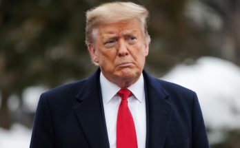 Donald Trump in winter coat and red tie