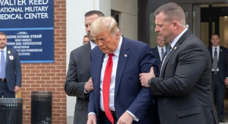 donald Trump in navy suit and red tie being escorted by Secret Service agents outside