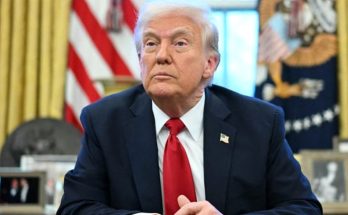 former President Donald Trump seated in the Oval Office with American flag and